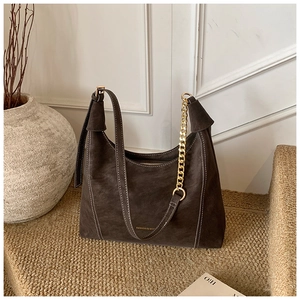 Detail of dark brown suede Hobo bag with white contrast stitching and gold chain strap