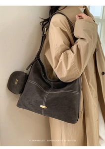 Detail of dark brown suede tote bag with contrast stitching and attached mini pouch