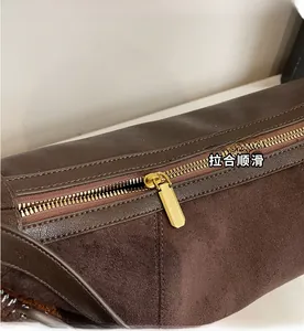 Détail de la fermeture éclair en métal doré sur le sac à main en cuir marron vintage