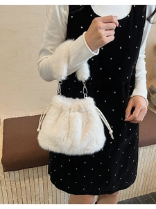 Détail d'un sac seau en fausse fourrure blanche avec cordon et garniture métallique