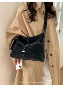 Detail of black matte leather tote with contrast white stitching and mini zipper pouch