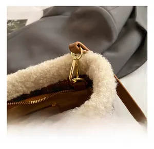 Dettaglio della borsa a secchiello a quadri con bordo in peluche e gancio in metallo oro