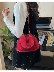 Détail du sac à main rouge en fausse fourrure avec cordon de serrage et poignée ronde en peluche