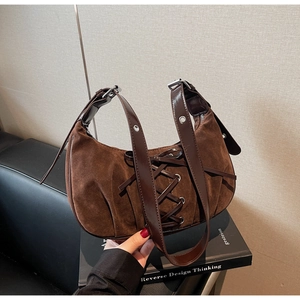 Close-up of brown suede underarm bag featuring ballet style lace-up ribbon details