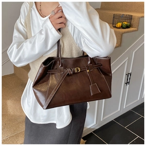 Close-up of vintage dark brown tote bag with white contrast stitching and gold D-ring detail