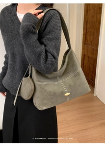 Detail of grey hobo bag showing contrast stitching and gold metal buckle with mini pouch
