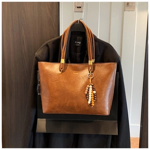 Détail du grand sac cabas vintage marron avec texture cuir et pendentif à pampilles