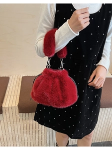 Détail d'un sac à main en fausse fourrure rouge vif avec cordon de serrage et anneau métal