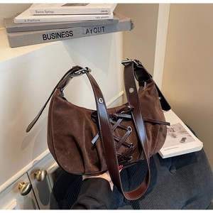 Detailed view of dark brown suede hobo bag featuring ballet-style leather ribbon ties
