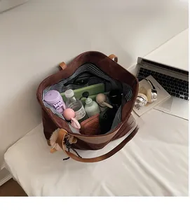 Top view of large brown suede tote bag showing spacious interior with daily essentials