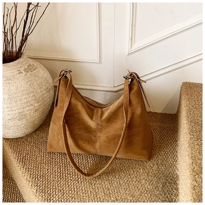 Detailed view of brown matte leather tote bag with vintage stitching on textured steps