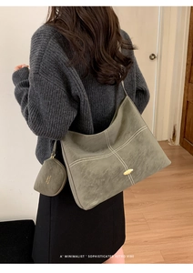 Close-up of retro grey suede tote bag with decorative white stitching and mini round pouch