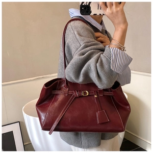 Détail du cabas bordeaux montrant le cuir brillant vintage et les surpiqûres