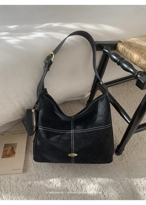 Detail of black faux leather tote bag with white contrast stitching and mini coin pouch