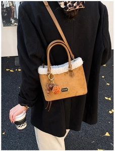 Brown faux suede bucket bag with white faux fur trim and decorative keychain details