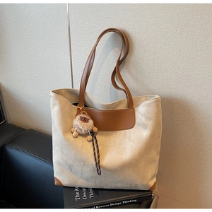 Détail du grand sac cabas blanc cassé avec anses en cuir marron et breloque peluche