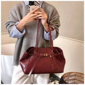 Close-up of vintage burgundy tote bag with white contrast stitching and gold D-ring buckle