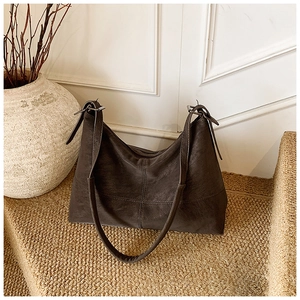 Detail of vintage brown leather hobo bag with cross stitching and adjustable strap
