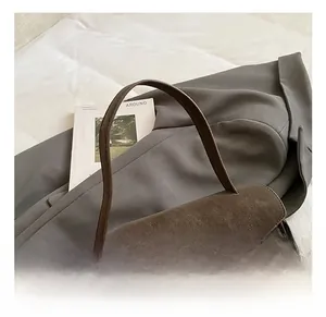 Detail view of dark brown vintage handbag with gold hardware clasp and matte texture finish