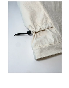 Macro detail of adjustable drawstring and toggle on beige tote bag with fine texture