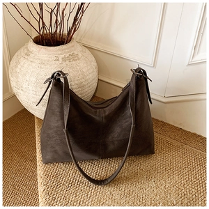 Detail of vintage brown suede tote bag with adjustable strap and antique silver hardware
