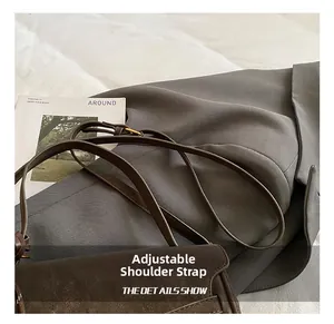 Detail shot of the adjustable leather shoulder strap on a brown vintage crossbody bag