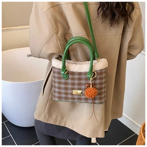 Close-up of retro plaid bucket bag with faux shearling trim and green leather strap