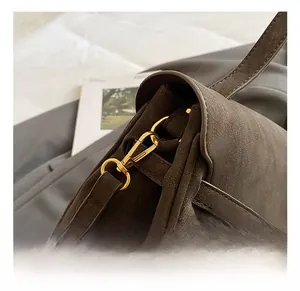 Detail view of the vintage brown leather bag showing premium gold metal buckle hardware