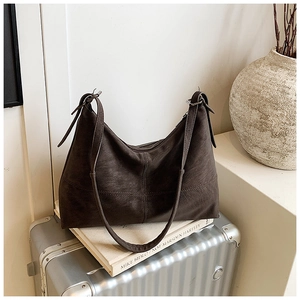 Close-up of vintage dark brown tote bag featuring soft leather texture and cross stitching