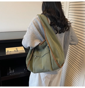 Detail of dark green corduroy tote bag showing vertical texture and zipper pocket