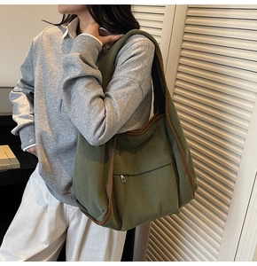 Detailed close-up of dark green corduroy tote bag with brown trim and front zipper pocket