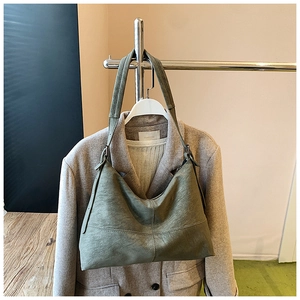 Detail of olive green retro textured faux leather hobo bag with decorative stitching