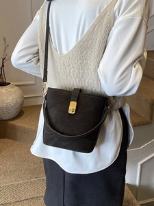 Brown bucket shoulder bag in matte leather finish with golden square twist lock