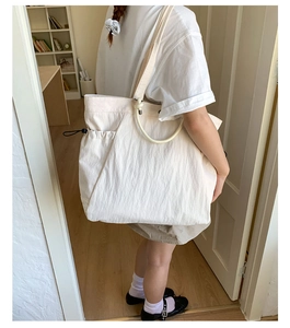 Detail of canvas tote bag with unique circular handle and elastic drawstring side pocket