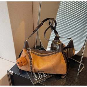 Vue détaillée du sac bandoulière en daim marron mat au design vintage en croissant