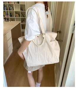 Close-up of cream white tote bag with adjustable drawstrings and functional double straps