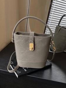 Chic dark grey minimalist leather bucket bag with top handle and vintage gold twist lock