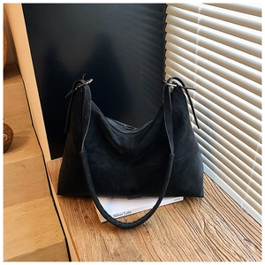 Detailed view of the black suede tote bag with side ties and soft matte texture