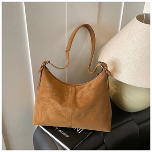 Detail of vintage brown leather hobo bag with a stylish knot strap on a leather seat