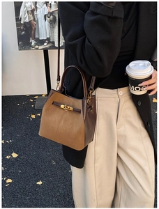 Brown leather bucket bag with gold twist lock shown in a stylish outdoor street style scene