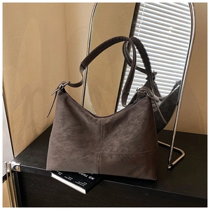 Detail of cross-stitched seam on vintage dark brown leather hobo shoulder bag
