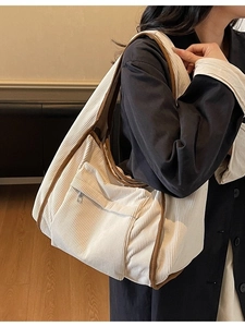 Minimalist corduroy tote bag in beige with brown trim shown on a model for daily style