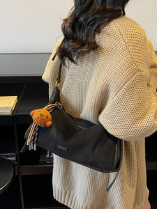 Sac bandoulière demi-lune noir avec un ours en peluche porté par un mannequin de dos