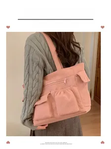 Pink corduroy tote bag showing large capacity front pockets and shoulder strap detail
