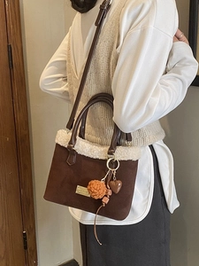 Brown frosted tote bag with white faux fur trim and colorful charms on a leather strap