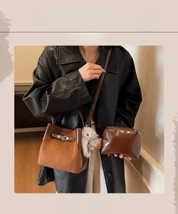 Dettaglio della borsa a secchiello vintage marrone con ciondolo e bustina interna