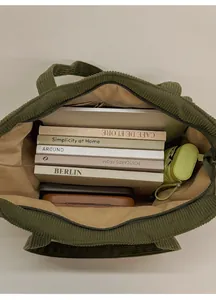 Detailed internal view of large green corduroy tote bag showing spacious capacity and pockets