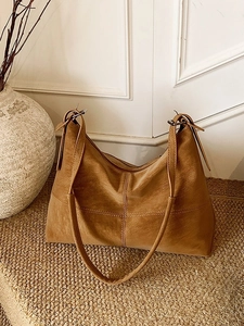 Vintage brown leather tote bag with cross-stitch design and wide shoulder strap