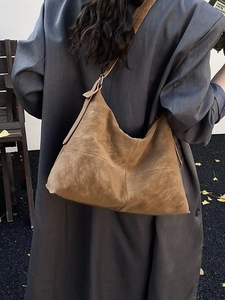 Vintage brown large capacity leather tote bag worn with a grey blazer for a casual look