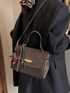 Deep brown matte leather shoulder bag with gold clasp and dachshund charm